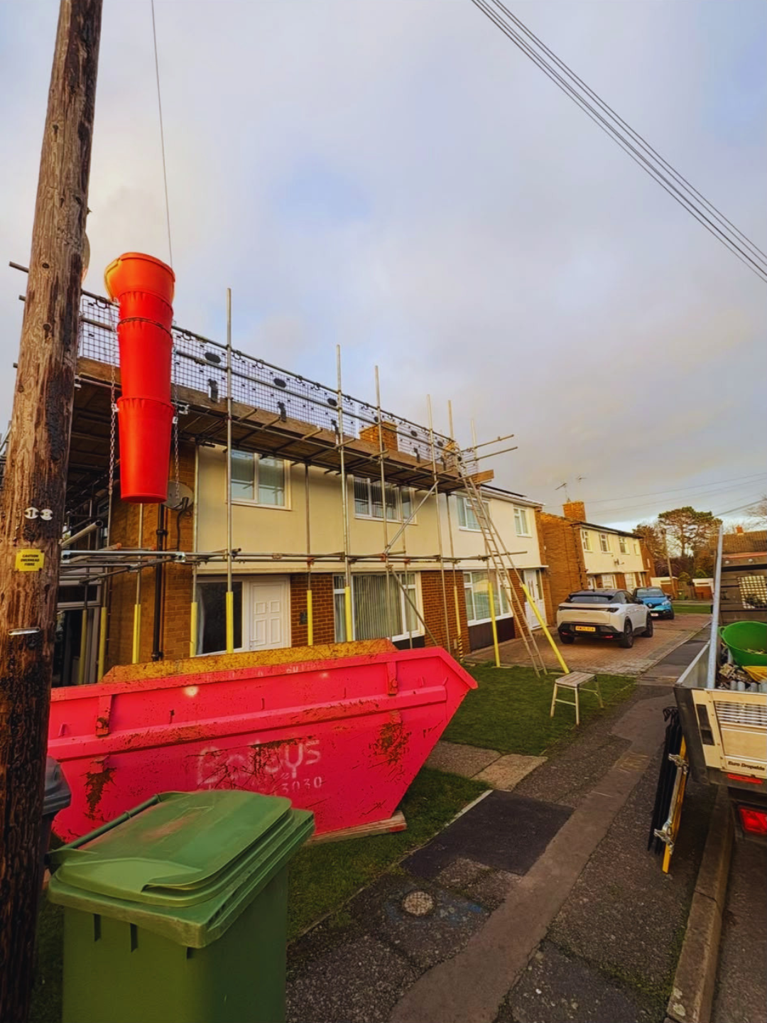 Roof scaffolding and skip on a residential street