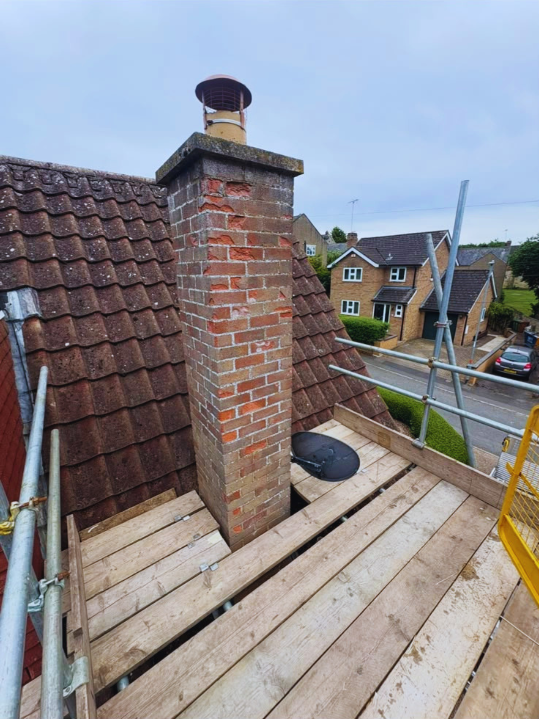 Boarded chimney platform built tight around a brick stack and flue