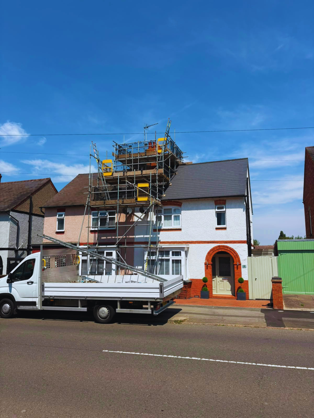 Chimney scaffolding with loading bay above the roofline