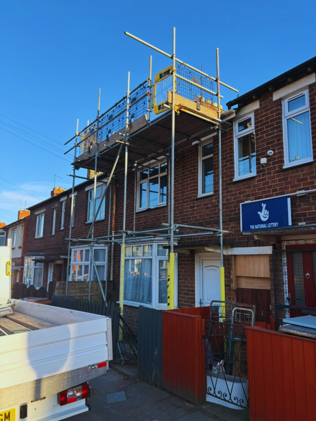 Roof scaffolding to a terraced property above a shop front